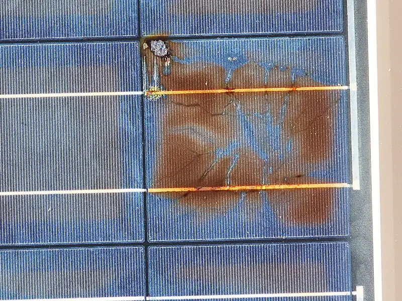 Nahaufnahme eines defekten Solarmoduls mit sichtbarem Schaden an einer Zelle