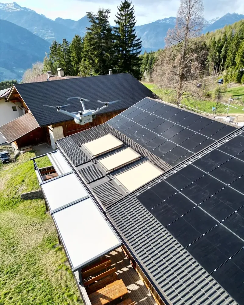 Drohne bei der Inspektion einer Photovoltaikanlage auf einem Dach in Südtirol